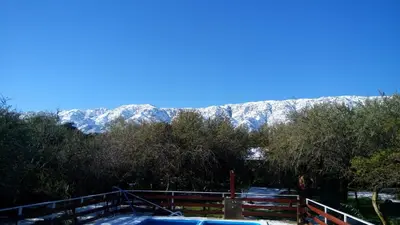 a snow covered mountain in the distance with a fence at Dorado del Sol in Merlo