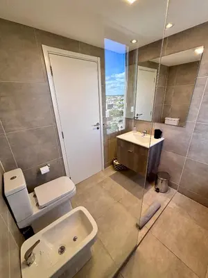 a bathroom with a toilet and a sink and a shower at Departamento moderno y lujoso con gym y piscina in Cordoba