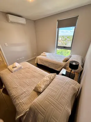 a hotel room with two beds and a window at Departamento moderno y lujoso con gym y piscina in Cordoba