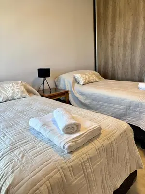 two beds with towels on them in a room at Departamento moderno y lujoso con gym y piscina in Cordoba