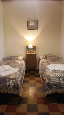 a room with two beds and a table with a mirror at Hotel del Alto in Nono