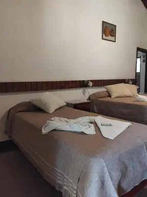 two beds in a hotel room with towels on the bed at Hotel del Alto in Nono