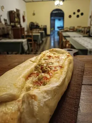 a pizza sitting on top of a wooden table at Hotel del Alto in Nono