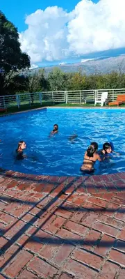 a group of people swimming in a swimming pool at Hotel del Alto in Nono