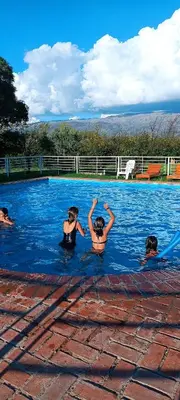 a group of people swimming in a swimming pool at Hotel del Alto in Nono