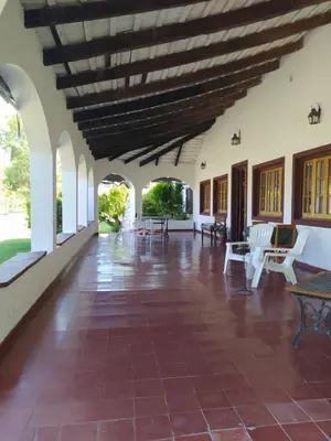 a large room with a red tile floor and a wooden ceiling at Hotel del Alto in Nono