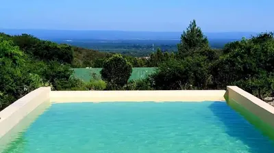 a large pool of blue water with trees in the background at Sol de Los Nogales in Merlo