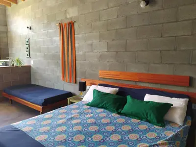 a bedroom with a bed with green and blue pillows at Sol de Los Nogales in Merlo
