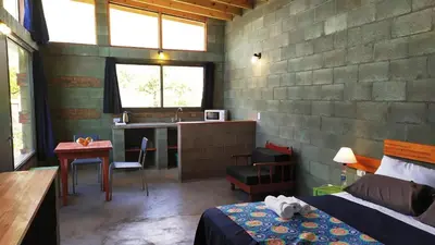 a bedroom with a bed and a desk and a kitchen at Sol de Los Nogales in Merlo
