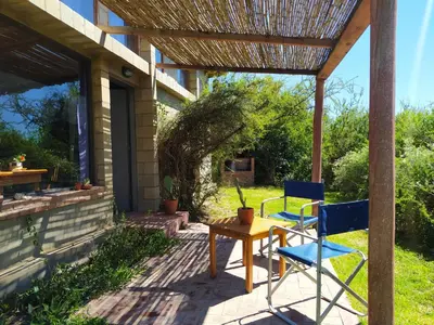 a patio with two chairs and a table and a pergola at Sol de Los Nogales in Merlo