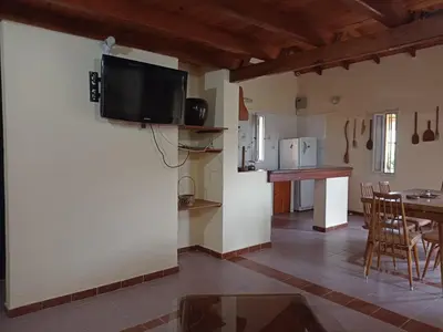 a kitchen and living room with a tv on the wall at Champ Cervi in San Antonio de Arredondo