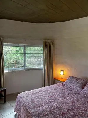 a bedroom with a bed and a large window at La Serena in Villa Carlos Paz