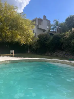 a large pool of blue water in a yard at La Serena in Villa Carlos Paz