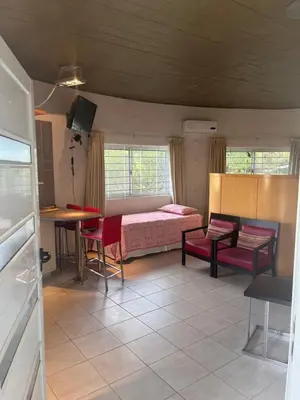 a room with a bed and a table and chairs at La Serena in Villa Carlos Paz