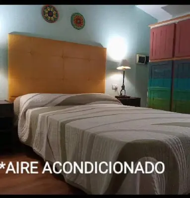 a bedroom with a large bed with a large headboard at Estacion Potrero cabaña chica in Potrero de Garay