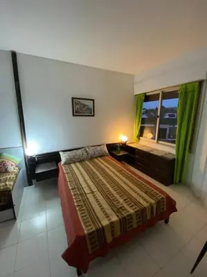 a bedroom with a large bed and a window at Departamento Villa Carlos Paz in Villa Carlos Paz