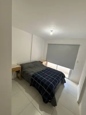 a bedroom with a bed with a blue plaid blanket at Departamento para 2 personas in Cordoba