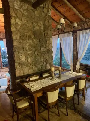 a dining room with a stone wall and a table and chairs at Casa de ensueño in Villa Carlos Paz