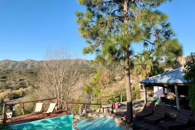 a house with a swimming pool and a tree at Casa de ensueño in Villa Carlos Paz