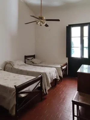 a room with three beds and a ceiling fan at Las Magnolias 4 dormitorios in Merlo
