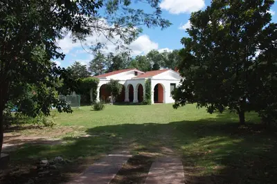 a house in the middle of a grassy yard at Las Magnolias 4 dormitorios in Merlo