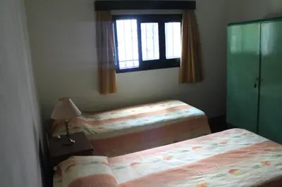 a bedroom with two twin beds and a window at Las Magnolias 4 dormitorios in Merlo