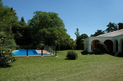 a swimming pool in a yard next to a building at Las Magnolias 4 dormitorios in Merlo