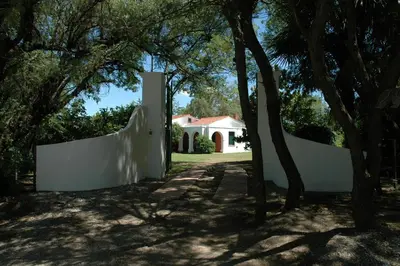 a white fence in front of a house at Las Magnolias 4 dormitorios in Merlo