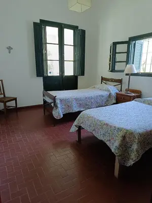 a room with two beds and two windows at Las Magnolias 4 dormitorios in Merlo
