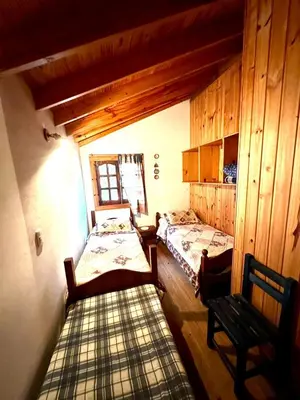 a room with two beds and a bench in it at Auken Penkoken in Merlo
