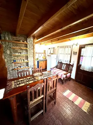 a living room with a wooden table and chairs at Auken Penkoken in Merlo