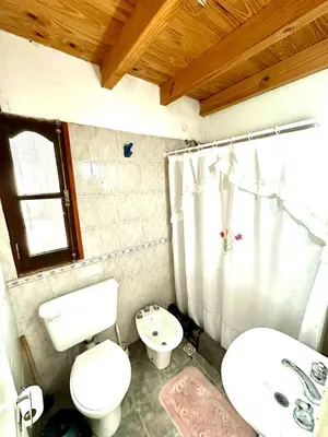 a bathroom with a white toilet and a sink at Auken Penkoken in Merlo