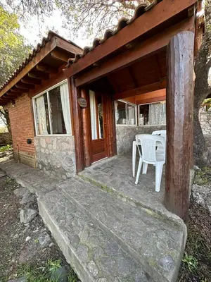 a porch of a house with a table and a chair at Auken Penkoken in Merlo
