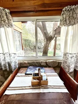 a bed in a room with a large window at Auken Penkoken in Merlo