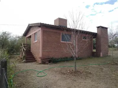 a house with a green hose in front of it at Casa con gran jardín a 100 mts del Río Amboy in Villa Amancay