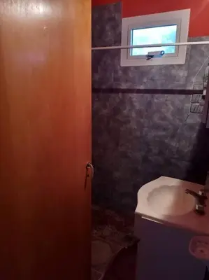 a bathroom with a door and a sink and a window at Casa con gran jardín a 100 mts del Río Amboy in Villa Amancay
