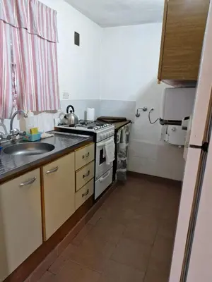 a small kitchen with a stove and a sink at Lo de Juan in Villa General Belgrano