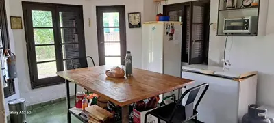 a kitchen with a wooden table and a refrigerator at Casa de campo EL LULI in La Bolsa