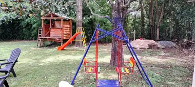 a playground with a swing set and a tree at Casa de campo EL LULI in La Bolsa