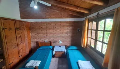 a room with two beds and a window at Complejo NONA RITA in Villa Cura Brochero