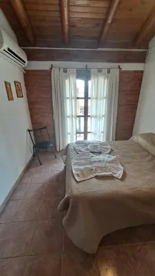 a large bed in a room with a large window at Complejo NONA RITA in Villa Cura Brochero