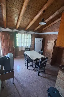 a kitchen with a table and chairs in a room at Complejo NONA RITA in Villa Cura Brochero