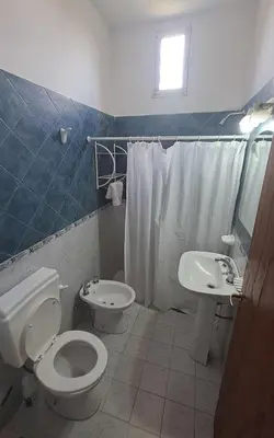 a bathroom with a toilet and a bidet and a sink at Complejo NONA RITA in Villa Cura Brochero