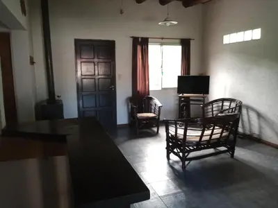 a living room with a table and chairs and a door at Casa con piscina en entorno muy verde in Villa Anizacate