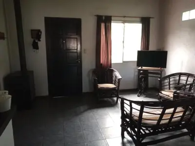 a living room with two chairs and a television at Casa con piscina en entorno muy verde in Villa Anizacate