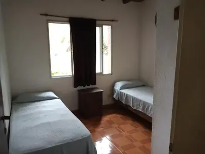 a small room with two beds and two windows at Casa con piscina en entorno muy verde in Villa Anizacate