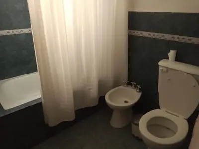a bathroom with a white toilet and a shower at Casa con piscina en entorno muy verde in Villa Anizacate