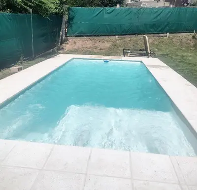 a swimming pool with blue water in a yard at Casa REFUGIO PUNILLA in Cordoba