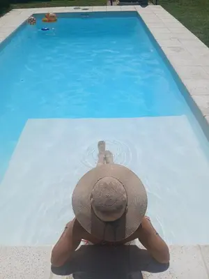 a person with a hat sitting in a swimming pool at Casa REFUGIO PUNILLA in Cordoba