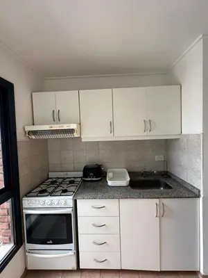 a kitchen with white cabinets and a stove top oven at Departamento alquiler temporal 6 D INVERHOME INMOBILIARIA in Cordoba
